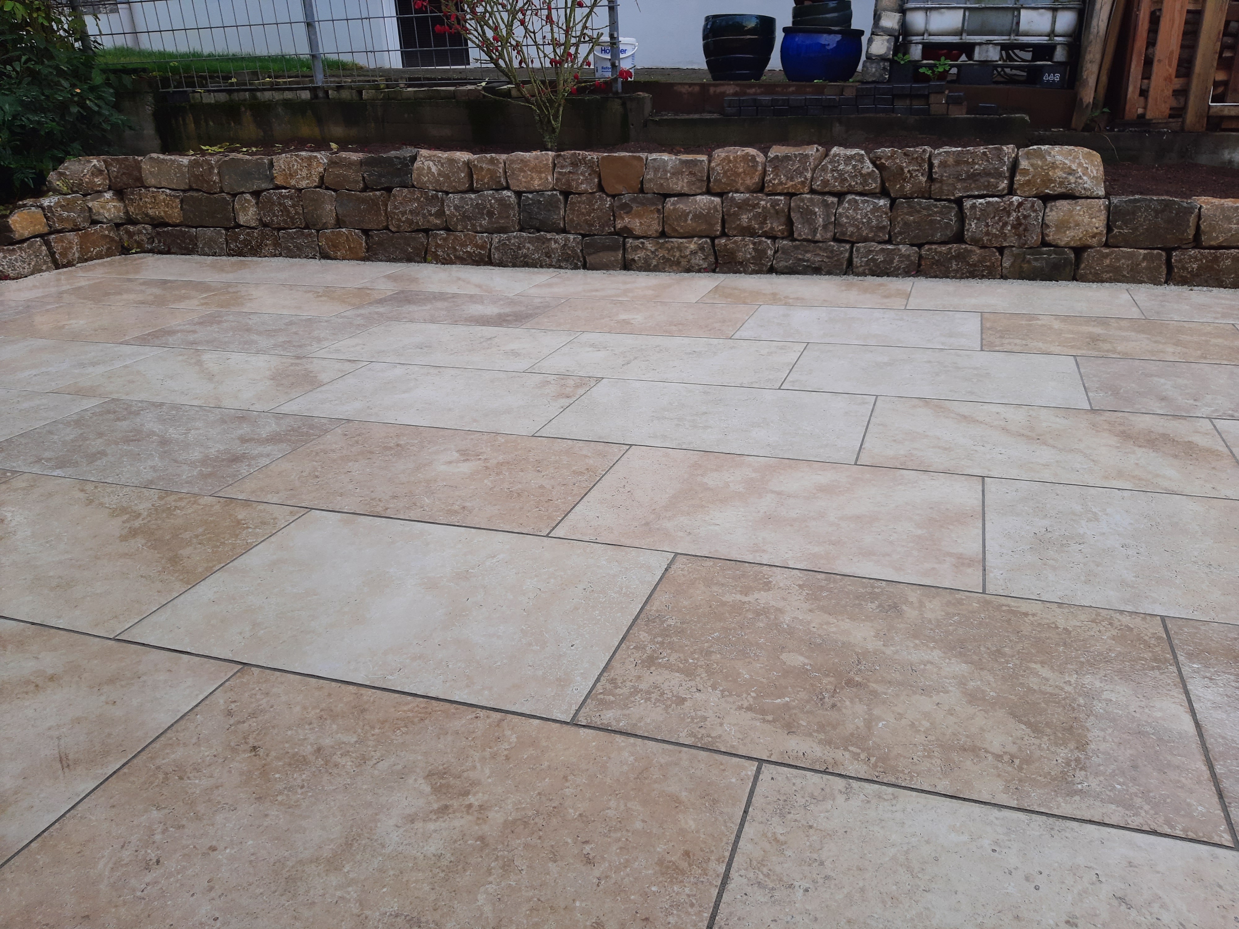 Keramikterrasse mit Natursteinmauer